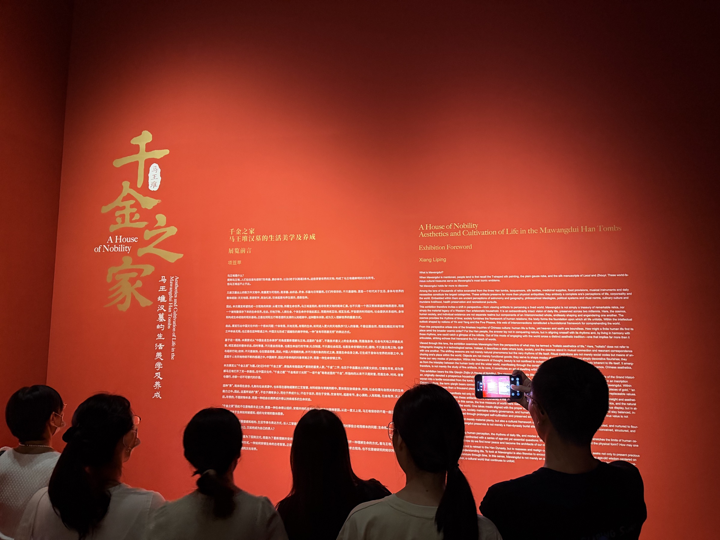 千金之家展览的红色前言墙，观众在墙前阅读和拍照